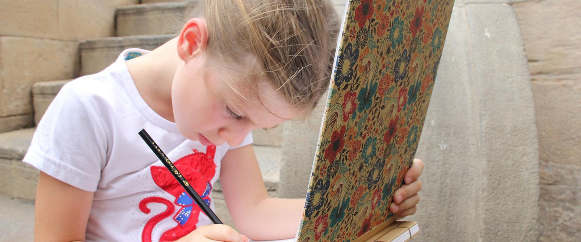 Petite fille qui dessine dehors